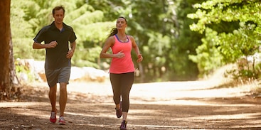 Man en vrouw lopen hard in het bos