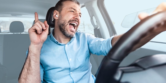 Man zingend in een auto