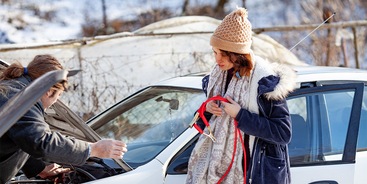 vrouw startkabels bij auto