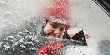 Vrouw ruit krabben auto ijsvrij maken