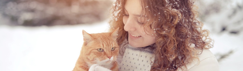 Vrouw houdt kat vast in sneeuw