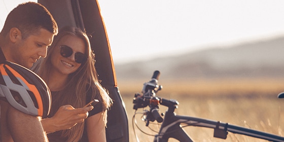 man en vrouw met racefiets  kijken naar smartphone