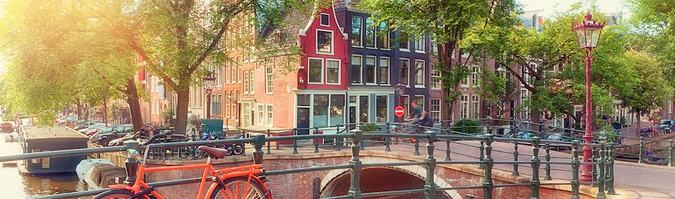 Oranje fiets op brug bij gracht