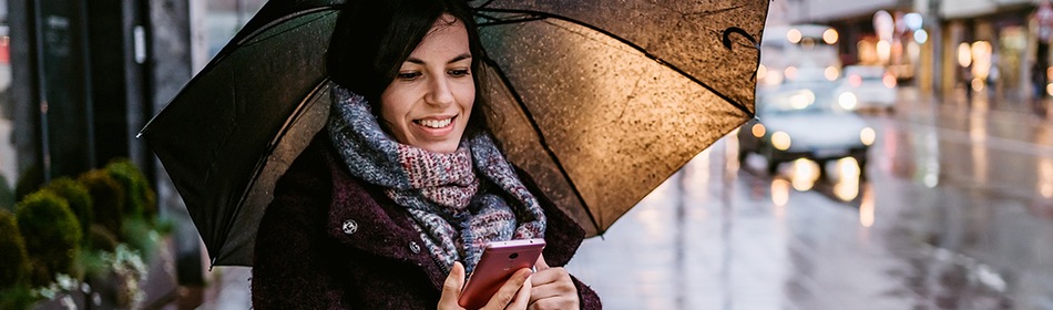 Vrouw met smartphone onder paraplu